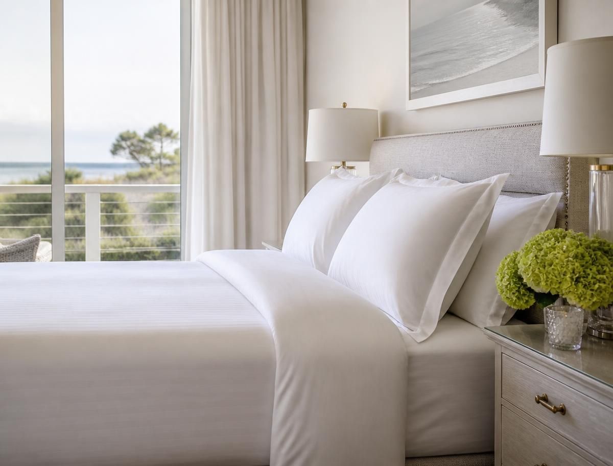 Neatly made bed with crisp white linens in a bright bedroom